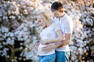 Happy couple expecting baby, pregnant woman with husband, young family and new life concept