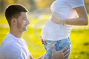 Happy couple expecting baby, pregnant woman with husband, young family and new life concept