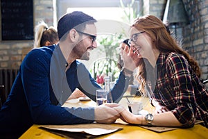 Happy couple flirting and dating in restaurant