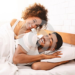 Happy couple flirting in morning on comfortable bed