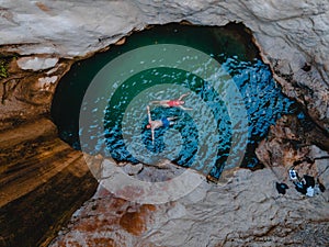 happy couple floating in waterfall lake overhead top view