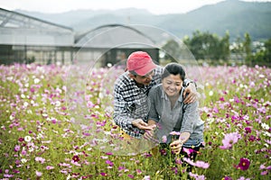 Happy couple at flower garden interact affectionately