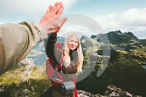 Happy couple friends giving five hands hiking in mountains