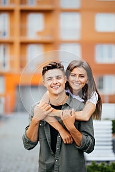 Happy couple or friends hugging on the street after encounter summer