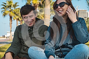 Happy couple or friends laughing in city park, man and woman spend time together