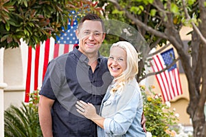 Happy Couple In Front of Houses with American Flags
