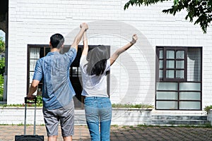 Happy couple in front of the New Home On Moving In Day, and start a new life family. Concept of homeowner and relocation