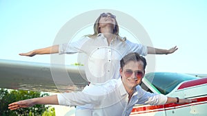 Happy couple in front of the parked small airplane plane. The concept of happiness, honeymoon