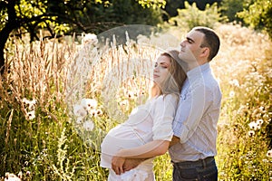 Happy couple future parents relaxing on nature, happy family, pregnancy