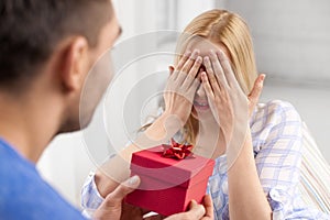 Happy couple with gift box at home