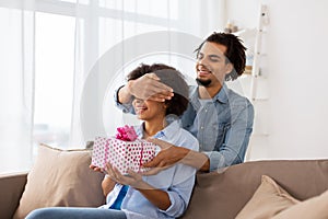 Happy couple with gift box at home