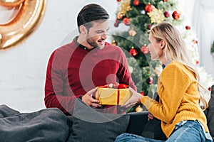 happy couple gifting present at home