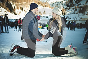 Happy couple, girls and boy ice skating outdoor at rink