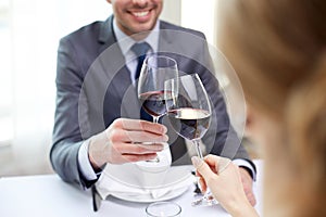 Happy couple with glasses of wine at restaurant