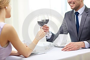 Happy couple with glasses of wine at restaurant