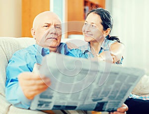 Happy couple of grandparents with newspaper