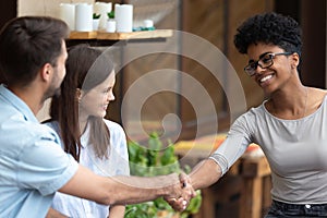 Happy couple handshake female specialist at meeting