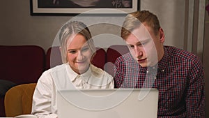 Happy couple has video call chatting with friends and family on laptop at home. young family talking video calling from