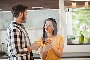 Happy couple having coffee in kitchen