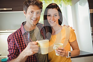 Happy couple having coffee in kitchen