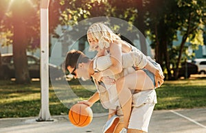 happy couple having fun on basketball playground