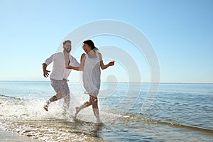 Happy couple having fun at beach. Honeymoon trip