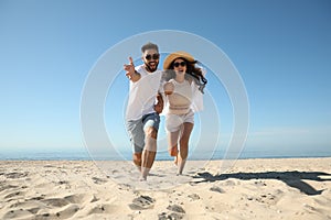 Happy couple having fun on beach near sea. Honeymoon trip