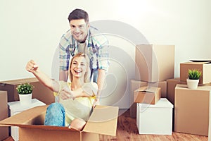 Happy couple having fun with boxes at new home