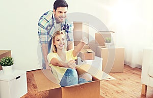 Happy couple having fun with boxes at new home