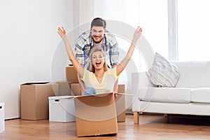 Happy couple having fun with boxes at new home