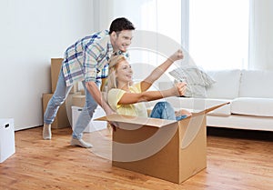 Happy couple having fun with boxes at new home