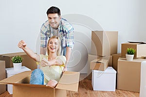 Happy couple having fun with boxes at new home