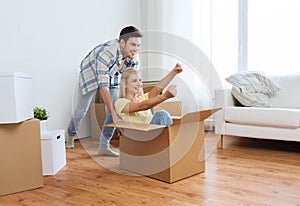 Happy couple having fun with boxes at new home