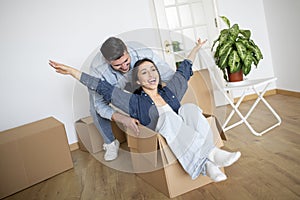 Happy Couple Having Fun With Cardboard Boxes At Home In Moving Day