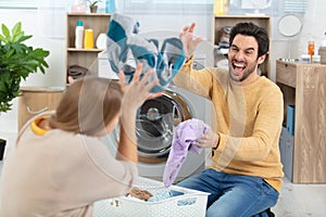 Happy couple having fun doing laundry together