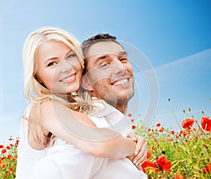 Happy couple having fun over poppy flowers field