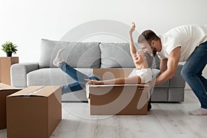 Happy couple having fun playing with cardboard box moving in