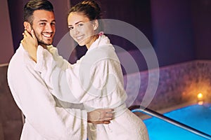 Happy couple having fun in pool luxury spa resort hotel - Romantic young people doing relaxing wellness treatment together