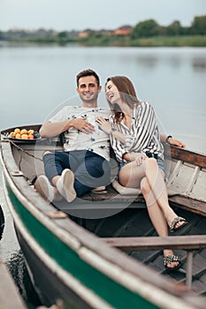 Happy couple having fun relaxing in boat on lake