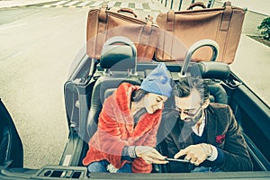 Happy couple having fun with satnav at car travel