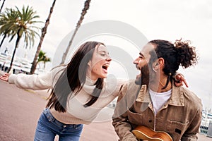 Happy couple having fun singing and dancing outdoors