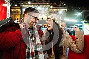 Happy couple having fun together on Christmas shopping. Holiday present people happiness concept