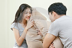 Couple having pillow fight on bed