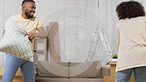 Happy couple having pillow fight at new home