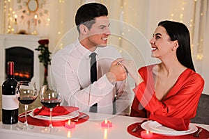 Happy couple having romantic dinner on Valentine`s day in restaurant
