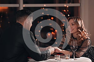 Happy couple having romantic dinner on Valentine`s day in restaurant