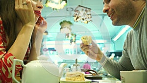 Happy couple having their dessert in a cafe. Man regales girl with a cake