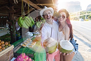 Happy Couple Hold Fresh Coconut Embracing On Thailand Street Market, Tourists Man And Woman Young In Traditional Fruits