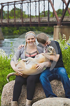 Happy couple holding dog in hands and smiling