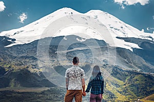Happy couple holding hands and enjoying the view of Mount Elbrus